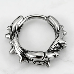Macro detail of punk style stainless steel hoop earring with bone-like spike texture