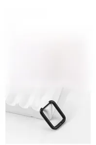 Macro detail of minimalist black matte titanium hoop earring on a white textured surface