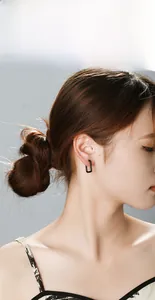 Close-up of model wearing black geometric square hoop earring in titanium steel