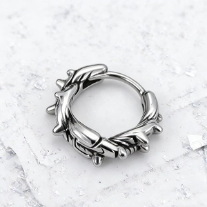 Detailed macro view of silver punk hoop earring featuring a sharp thorn textured finish