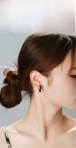 Gros plan d'une boucle d'oreille en forme de U en acier titane noir sur un mannequin