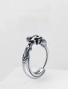 Detailaufnahme eines silbernen Edelstahlohrrings mit geprägten Punk-Mustern im Vintage-Stil