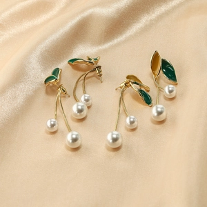 Boucles d'oreilles perles exquises avec feuilles d'émail vert sur tissu en soie champagne