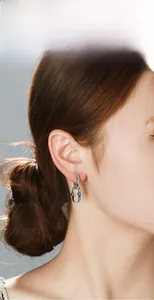 Gros plan de boucles d'oreilles chaînées argentées style punk sur modèle au design industriel