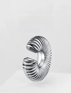 Macro shot of silver stainless steel earring with unique spiral ribbed texture design