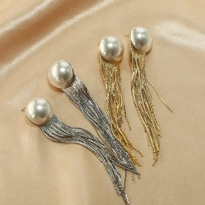 Detailansicht eleganter langer Perlenohrringe mit Quasten in Gold und Silber