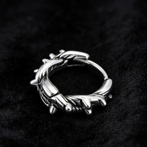 Macro detail of silver stainless steel thorn earring with polished punk spike design