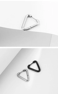 Gros plan de boucles d'oreilles triangulaires minimalistes en acier titane argent et noir