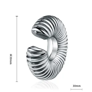 Detailed view of 30mm retro punk wolf tooth earring with grooved texture in steel