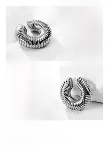Detail of a C-shaped titanium steel ear cuff with precision spiral textured patterns
