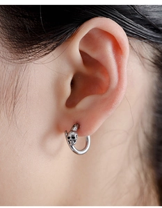 Close-up of vintage silver skull hoop earring in titanium steel for a gothic rock style