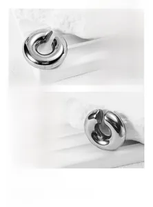 Macro shot of mirror-polished silver titanium steel earring on white textured stone