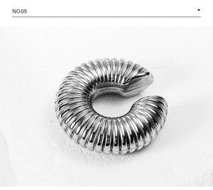 Detailed close-up of a silver C-shaped ear cuff with textured vertical ribbed patterns