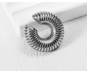 Macro shot of silver stainless steel earring featuring spiral radial texture and mirror finish