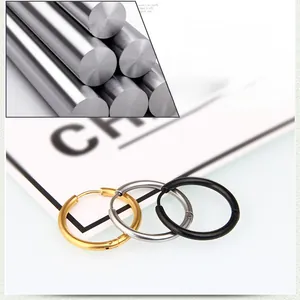 Détail macro de boucles d'oreilles créoles en acier titane poli en or, argent et noir