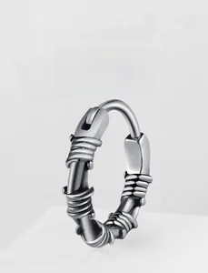 Macro shot of silver steel hoop earring with industrial wire-wrapped texture