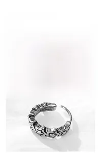 Macro view of vintage style steel ring featuring detailed embossed pentagram stars patterns