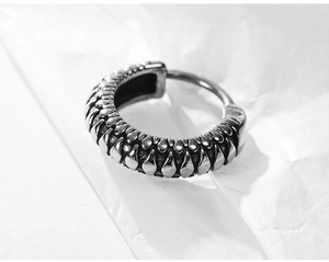Detailed macro view of vintage gothic silver hoop earring with scale-like 3D textures