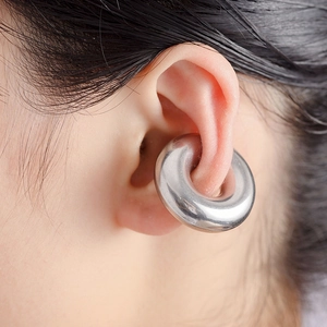 Retro punk style stainless steel oversized hoop earring worn as a heavy gauge ear piercing