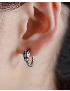 Macro detail of vintage snake scale texture on a blackened titanium steel hoop earring