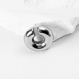 Polished silver punk wolf tooth hoop earring in stainless steel on white stone