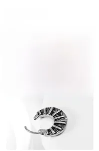 Detailed macro shot of vintage silver cross earring with textured horizontal grooved metal