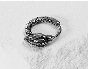 Macro detail of vintage dragon earring with intricate scale textures in steel