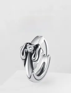 Detailed view of vintage silver hoop earring with wave texture and sparkling zircon stone