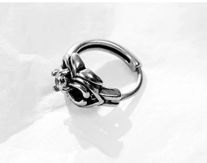 Macro detail of gothic vintage metal cross earring with sparkling round zircon stone
