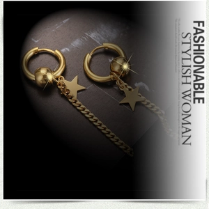Detail von goldenen Punk-Ohrringen mit Sternanhängern und Ketten auf Marmorhintergrund