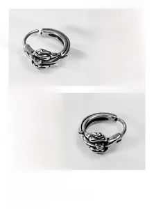 Detail of vintage titanium steel hoop earring with embossed texture and clear zircon stone
