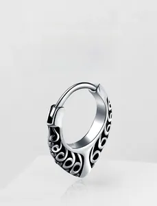 Detail of vintage silver hoop earring with engraved black scrollwork patterns