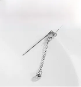 Macro detail of silver titanium steel long chain earrings with polished ball pendant