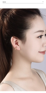 Close-up of a minimalist gold cross titanium steel hoop earring worn by a female model