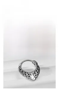 Macro detail of vintage tribal totem engravings on a silver steel horseshoe ear piercing