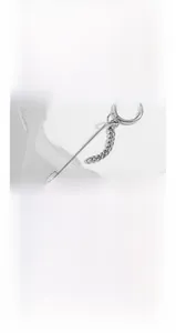 Close-up of minimalist titanium steel hoop earring with Cuban chain and spike detail