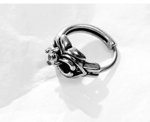 Macro shot of vintage silver cross earring with crystal inlay and gothic engravings