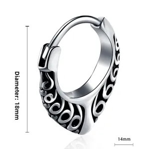Detailed macro view of vintage cross earring with black engraved textures and dimensions