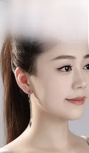 Detail of silver tapered cone earrings with chain tassel on a model in punk style
