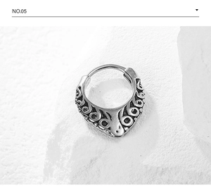 Detail of vintage silver stainless steel hoop with intricate scroll relief pattern