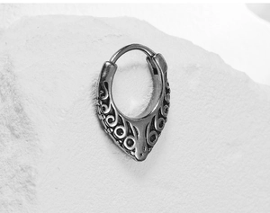 Macro shot of vintage titanium steel huggie earring with engraved patterns on stone