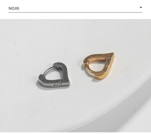 Polished heart-shaped hoop earrings in gold and silver finishes, detail view of metal pair