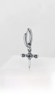 Close-up of gothic cross earring with skull sword design and black gemstone inlay