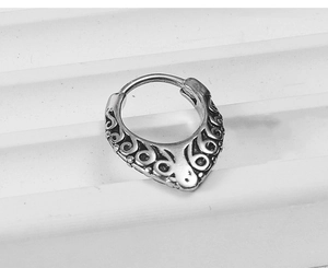 Detailed macro view of vintage silver steel nose ring with intricate floral carvings