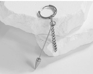 Close-up of silver punk drop earring with chain and conical spike on stone base