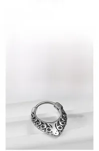 Close-up of vintage silver-tone nose ring featuring intricate hollow floral carvings