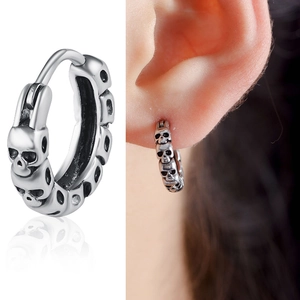 Macro detail of vintage silver skull hoop earrings with oxidized metal finish