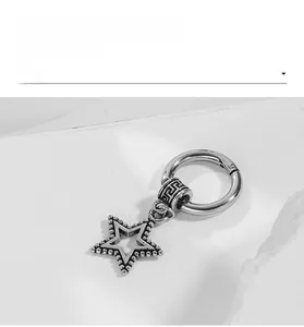 Macro shot of vintage silver steel hoop earring with hollow star pendant and meander pattern