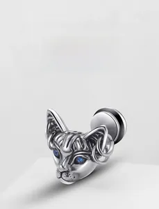 Detail of silver sphinx cat stud earring with blue gemstone eyes and hoop ear piercings