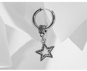 Close-up of vintage silver cross earring with meander bead and star pendant
